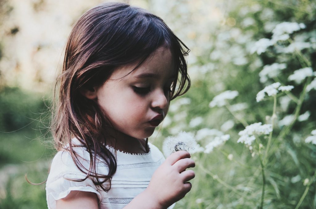 kind erkundet natur und blumen