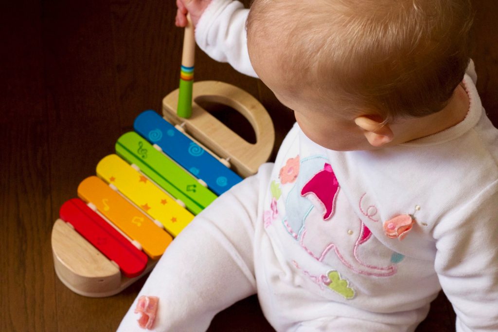 baby playing an instrument to enhance creative learning through music