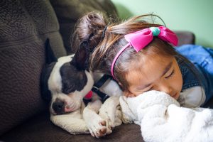 Kid cuddling with dog pet